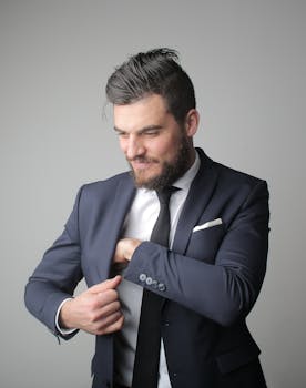 Man in Blue Suit Standing Near Gray Wall